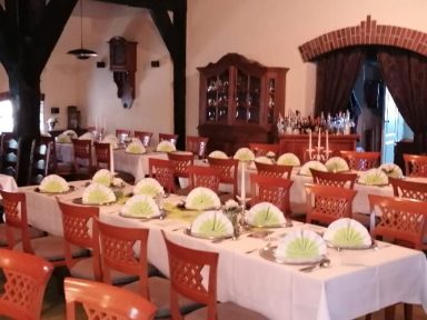 Tisch gedeckt mit grünen Servietten in einem eleganten Speisesaal.