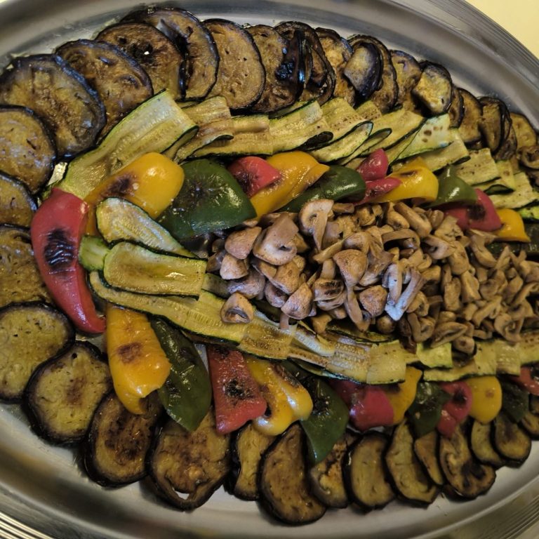 Gegrilltes Gemüsearrangement mit Auberginen, Zucchini und bunten Paprika, garniert mit Pilzen.
