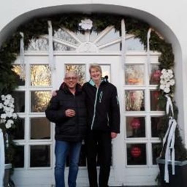 Zwei Personen stehen vor einer festlich dekorierten Eingangstür.